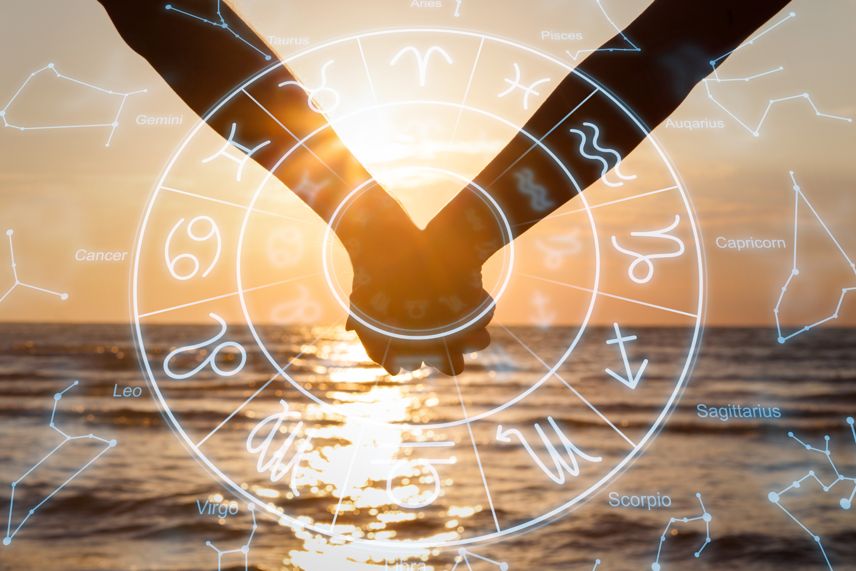 couple holding hands with zodiac wheel overlay in sunset