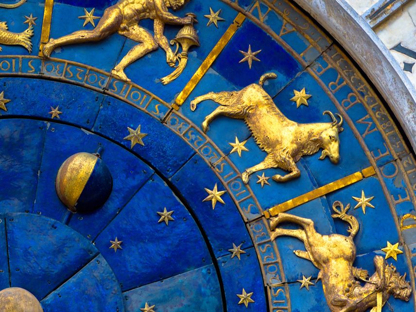 Capricorn astrological sign on ancient clock, Venice, Italy. Detail of old Zodiac wheel with constellations. Golden symbol of Capricorn on star circle close-up. Concept of Italian art and horoscope.